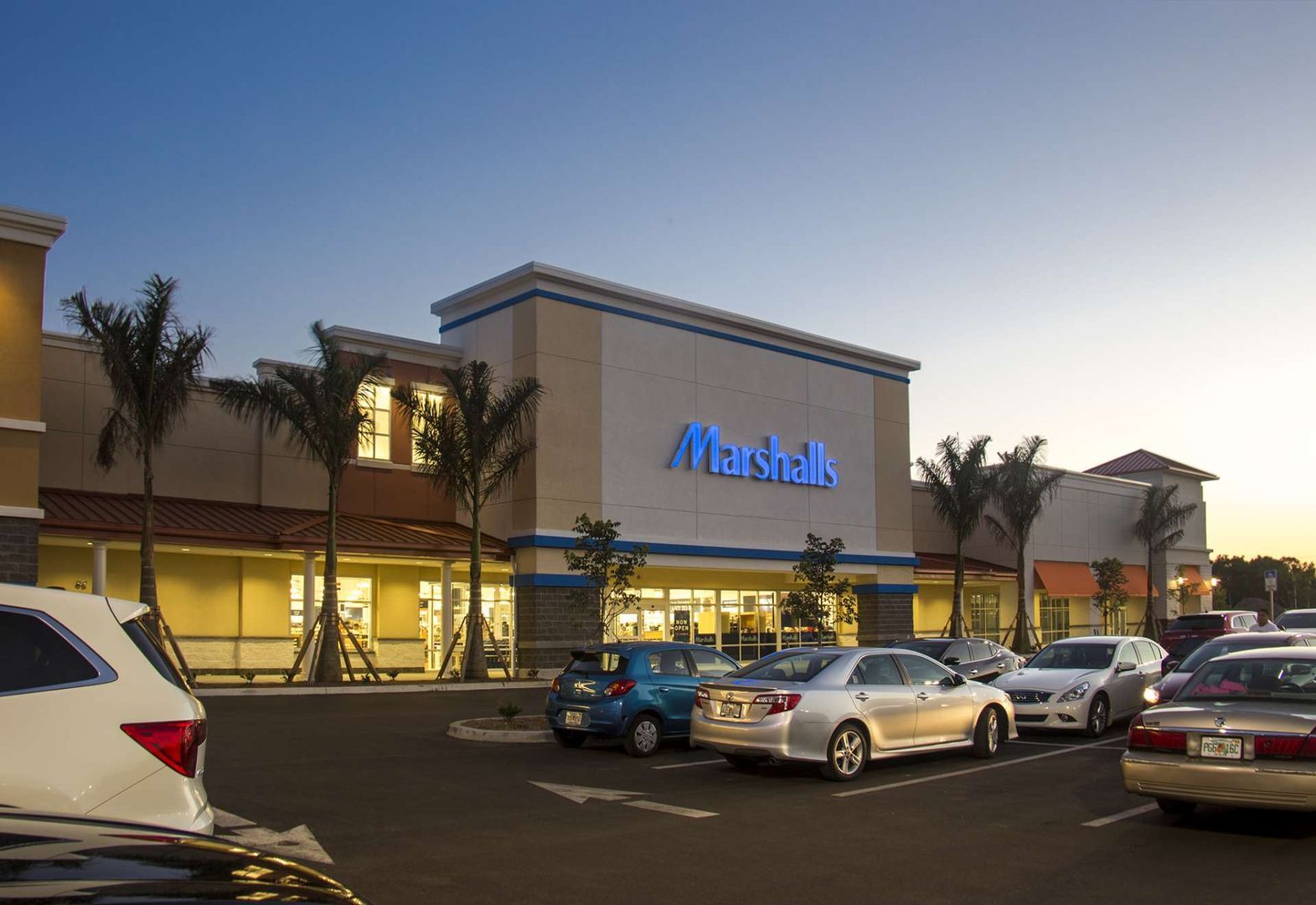 cars are parked in front of a marshalls store