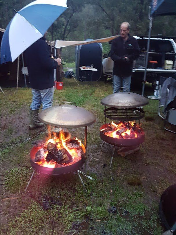 A group of people are standing around a fire pit.