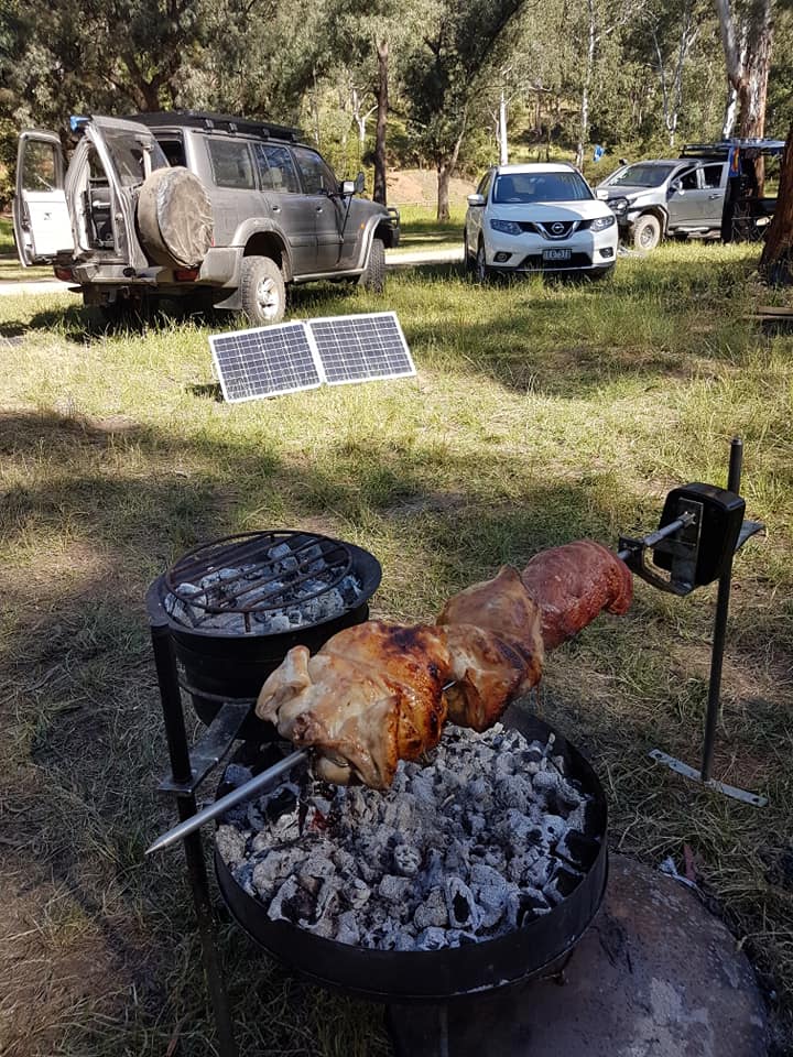 A chicken is being cooked on a battery spit over fire