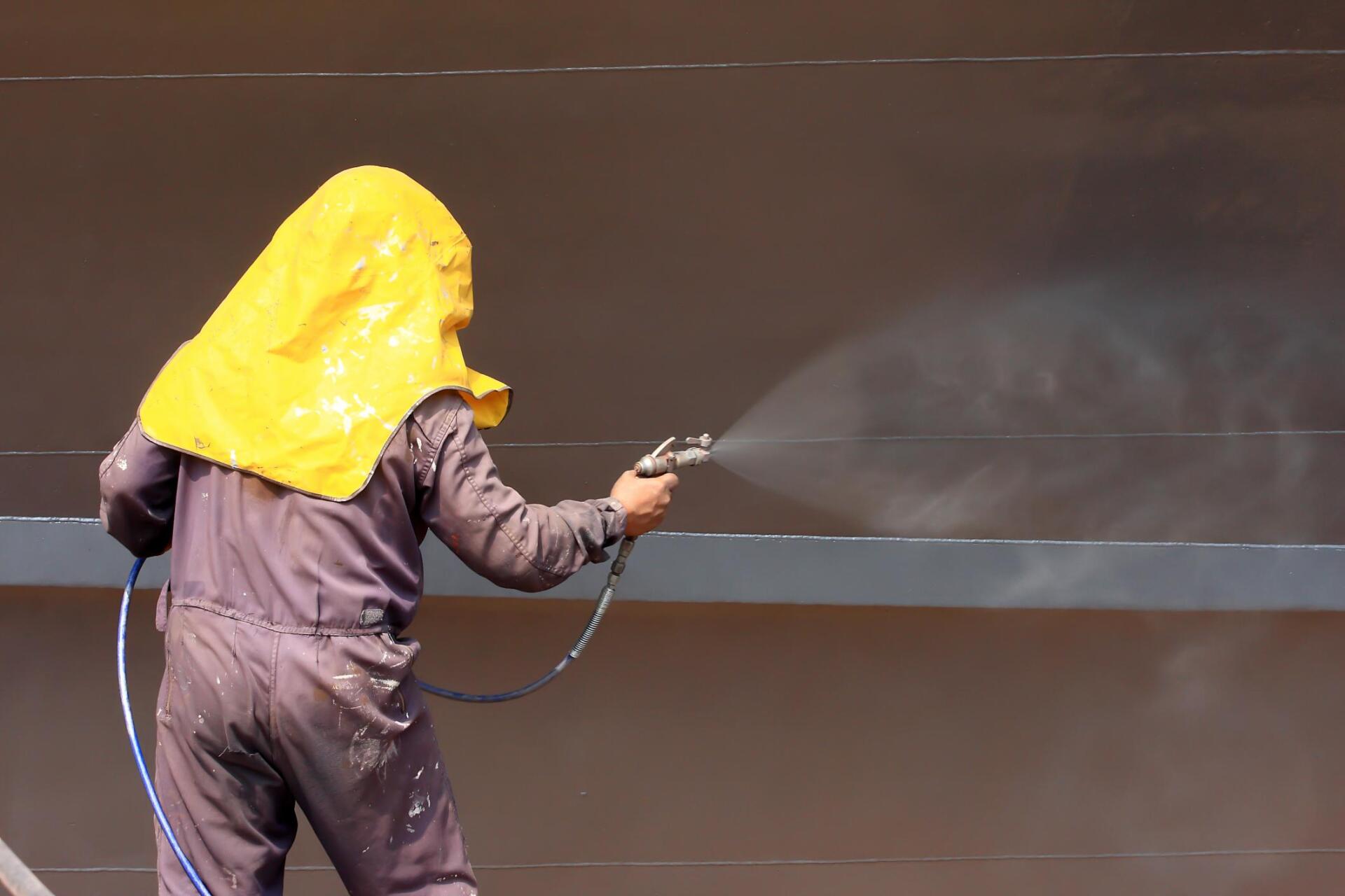 man in protective suit spraying the walls