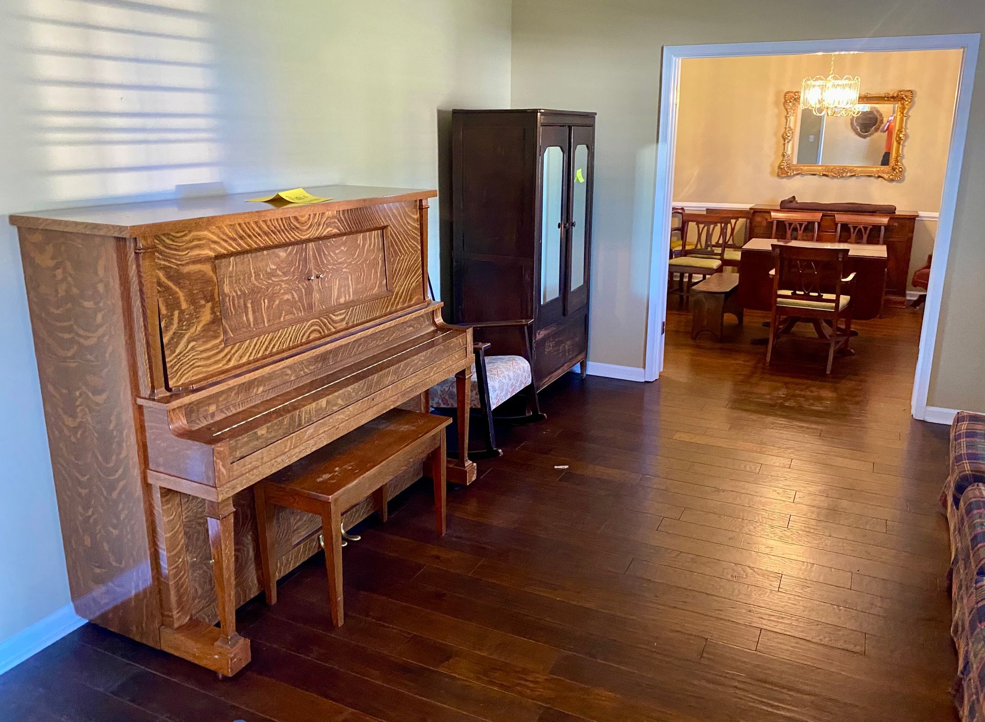 A piano is sitting in a living room next to a dining room.