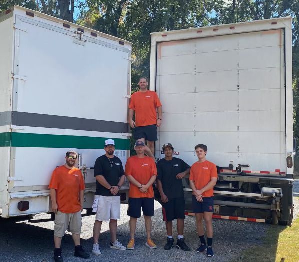 A group of men standing in front of a moving truck