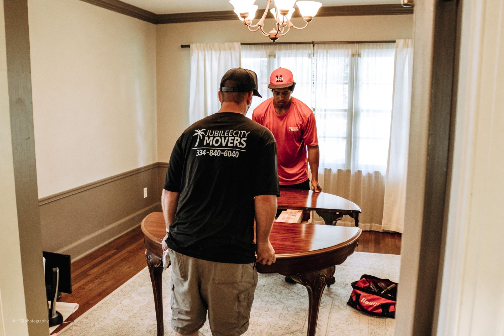 Two men are standing next to a table in a living room.