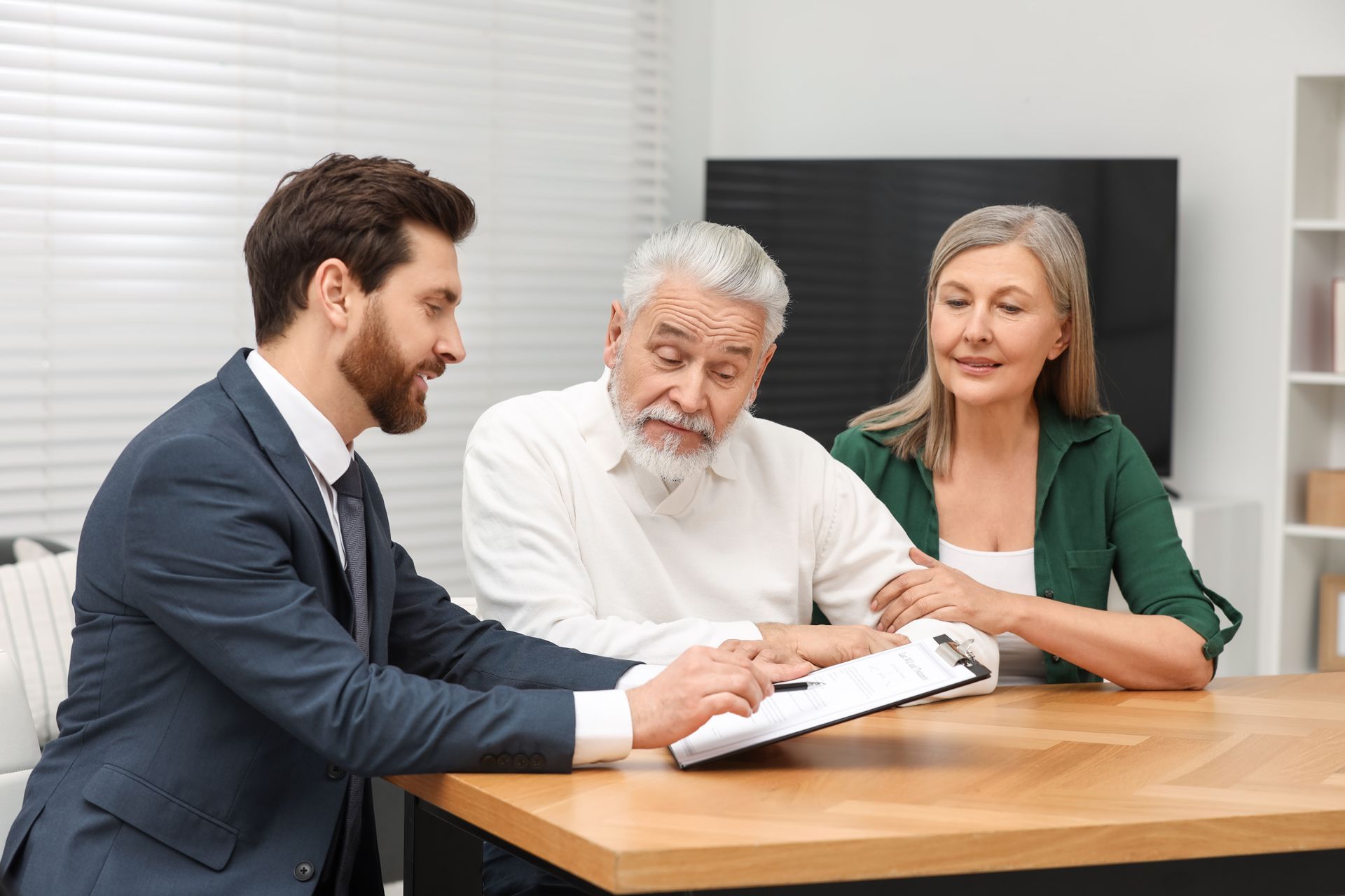 Financial advisor shows paperwork to elderly couple at a table