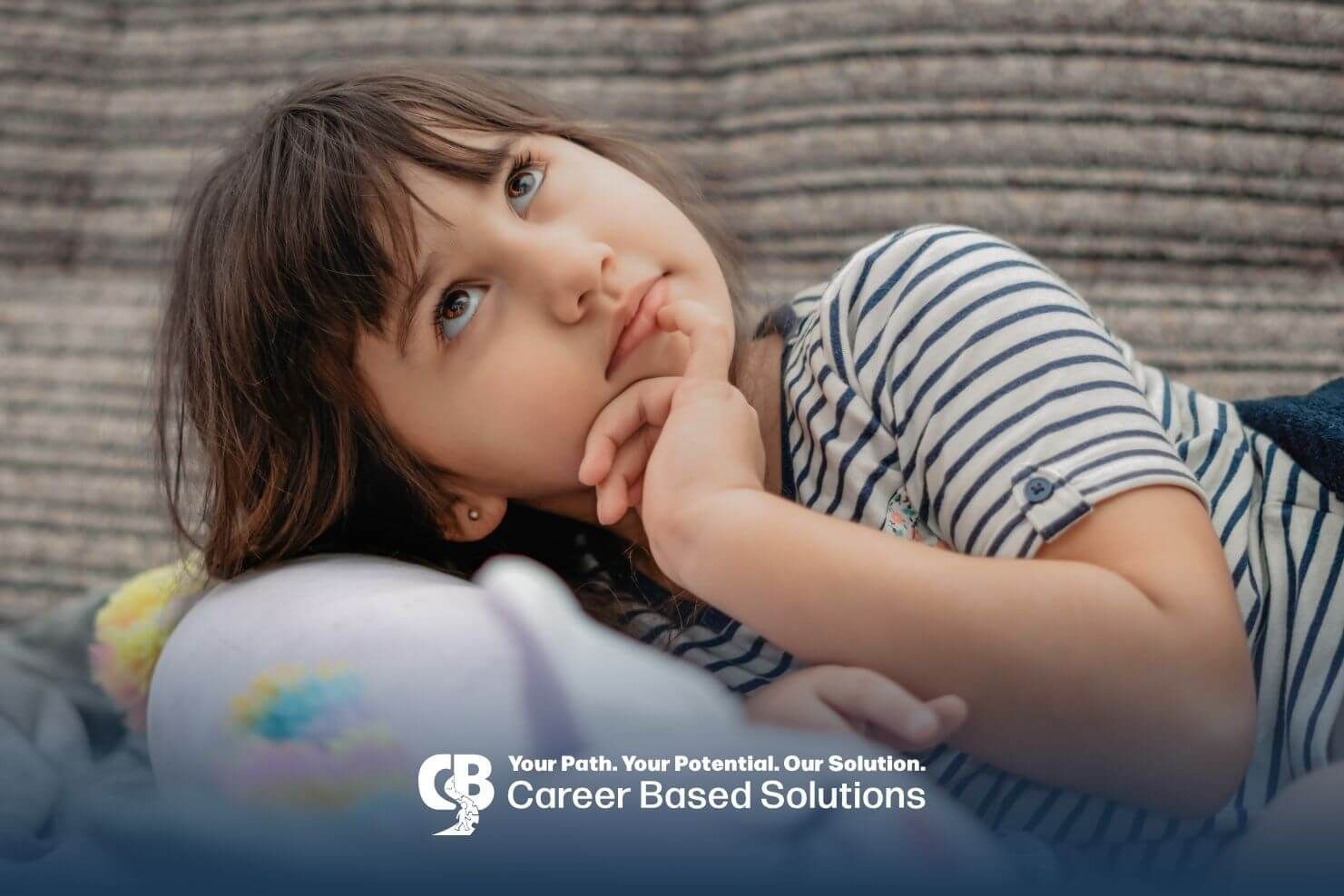 Autistic girl lying on pillow with thoughtful expression, showing quiet behavior and possible early 