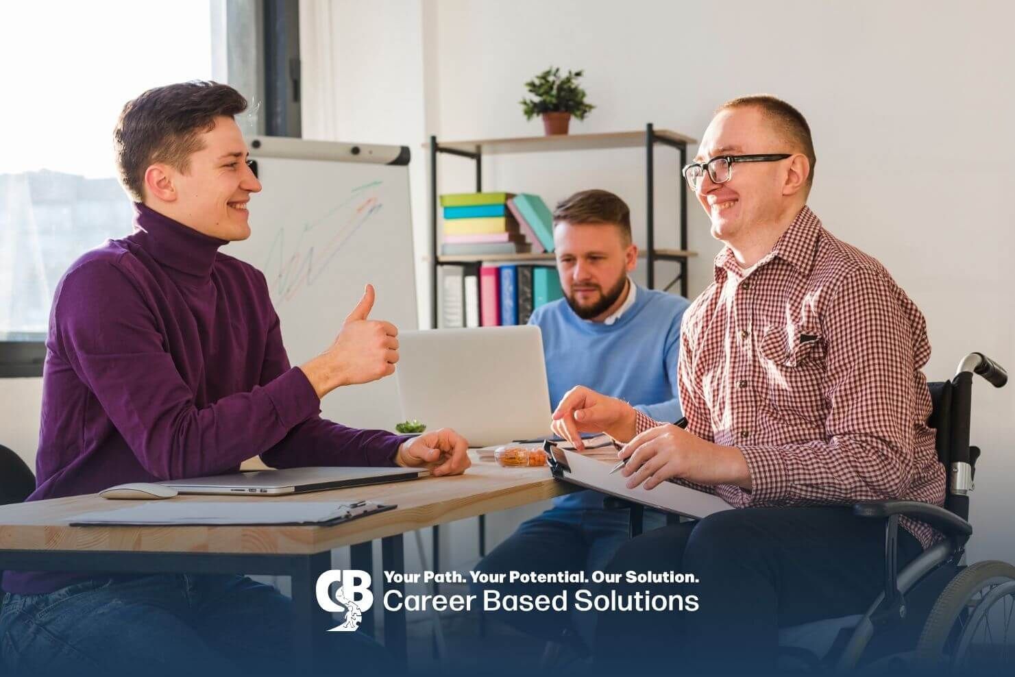 Autistic adults collaborating in office, including wheelchair user, highlighting the workplace