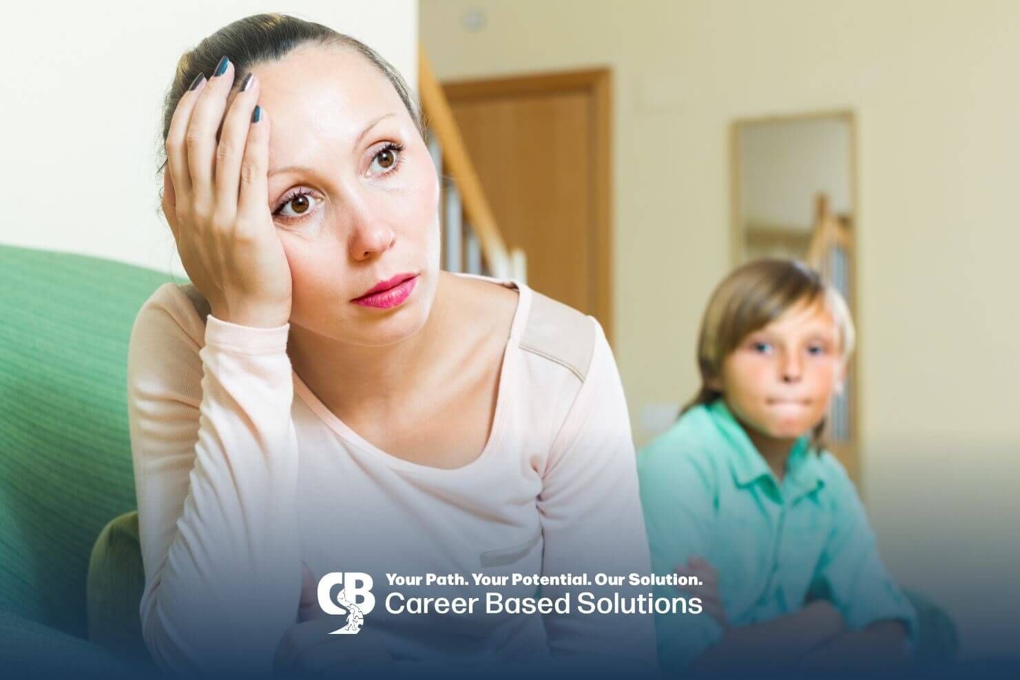 A therapist is sitting on a couch with her hand on her head, while autistic boy sits with his arms