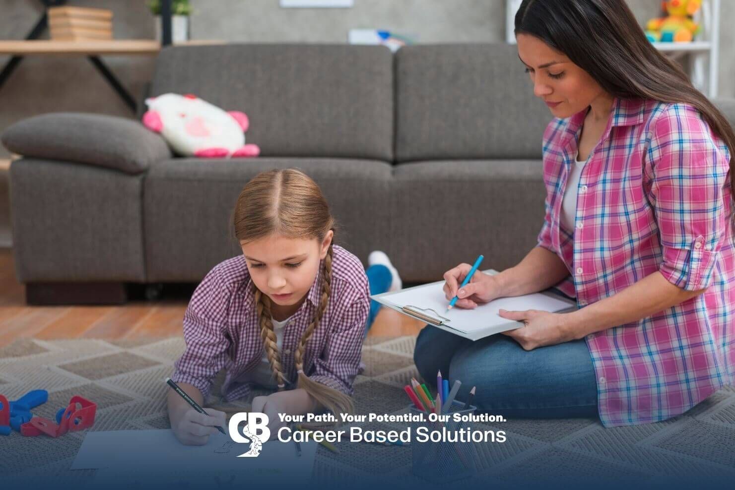 Therapist observing & taking notes while autistic girl draws on the floor during ABA therapy
