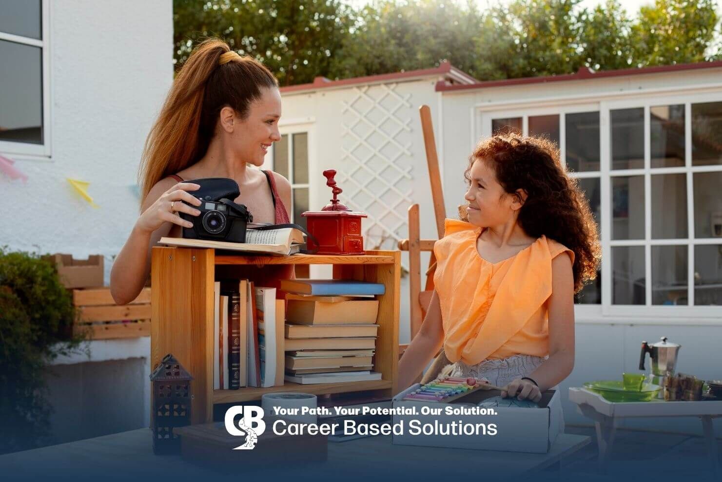 Therapist and autistic girl organizing books together outdoors, encouraging play-based learning.