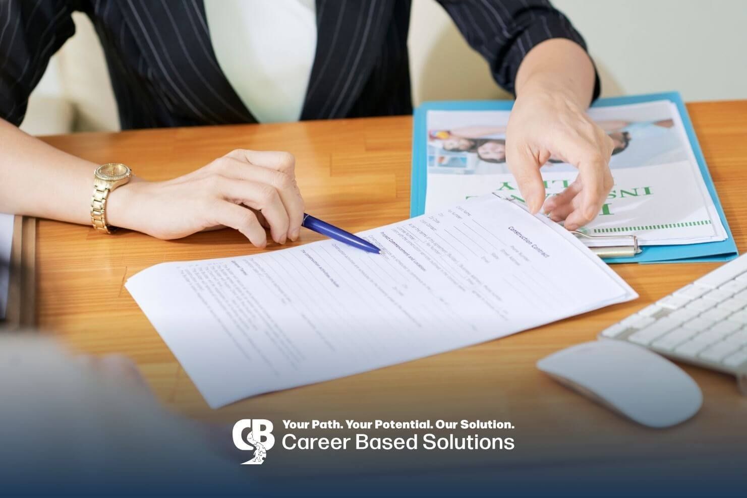 ABA woman in a pinstriped suit is sitting at a desk, pointing to a document while filling out a form