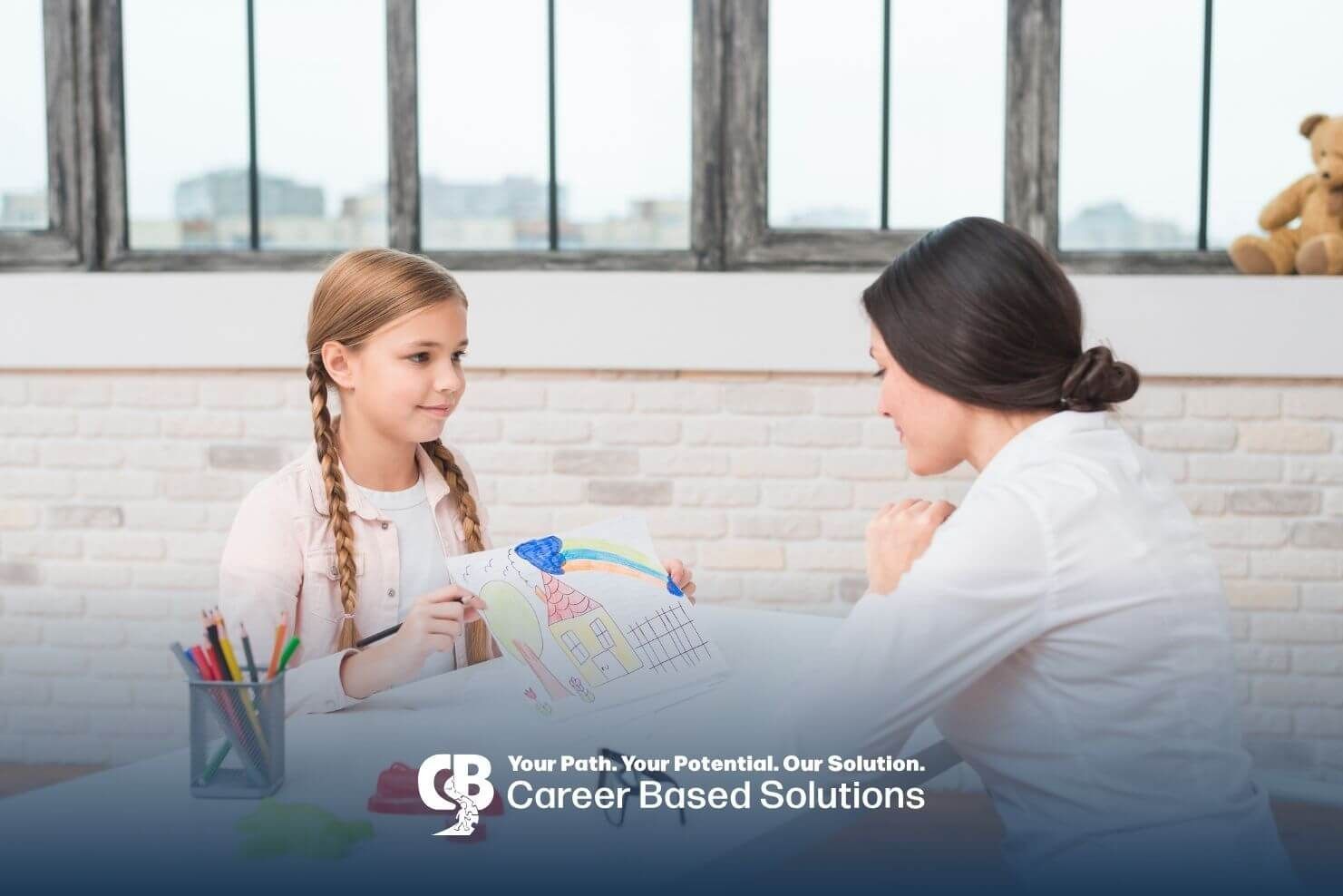 Autistic girl showing her drawing to therapist across table, building communication and confidence.