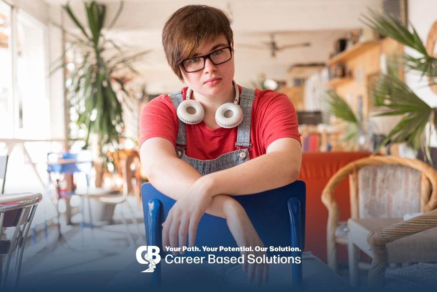 Autistic adult with headphones sitting indoors, showing sensory sensitivity and need for quiet space