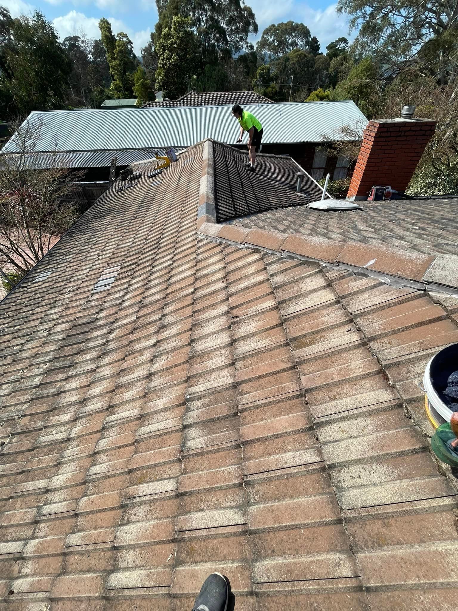 A man is standing on the roof of a house