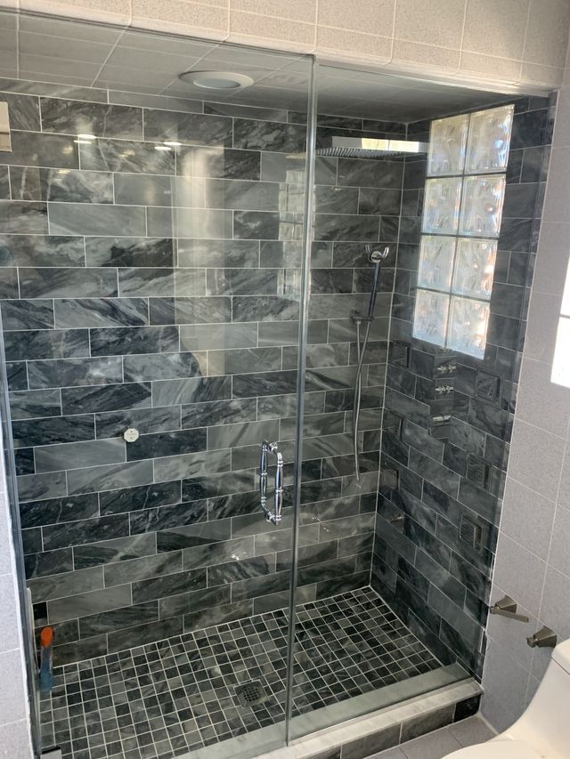 A bathroom with a walk in shower and a toilet.