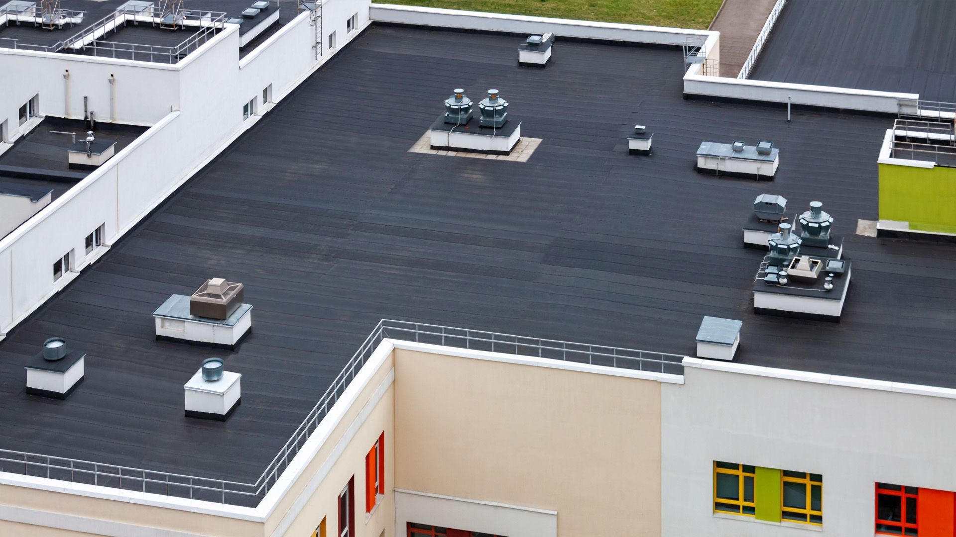 an aerial view of a building with a black roof
