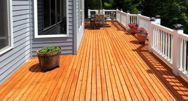 a wooden deck with a white railing and a potted plant on it .