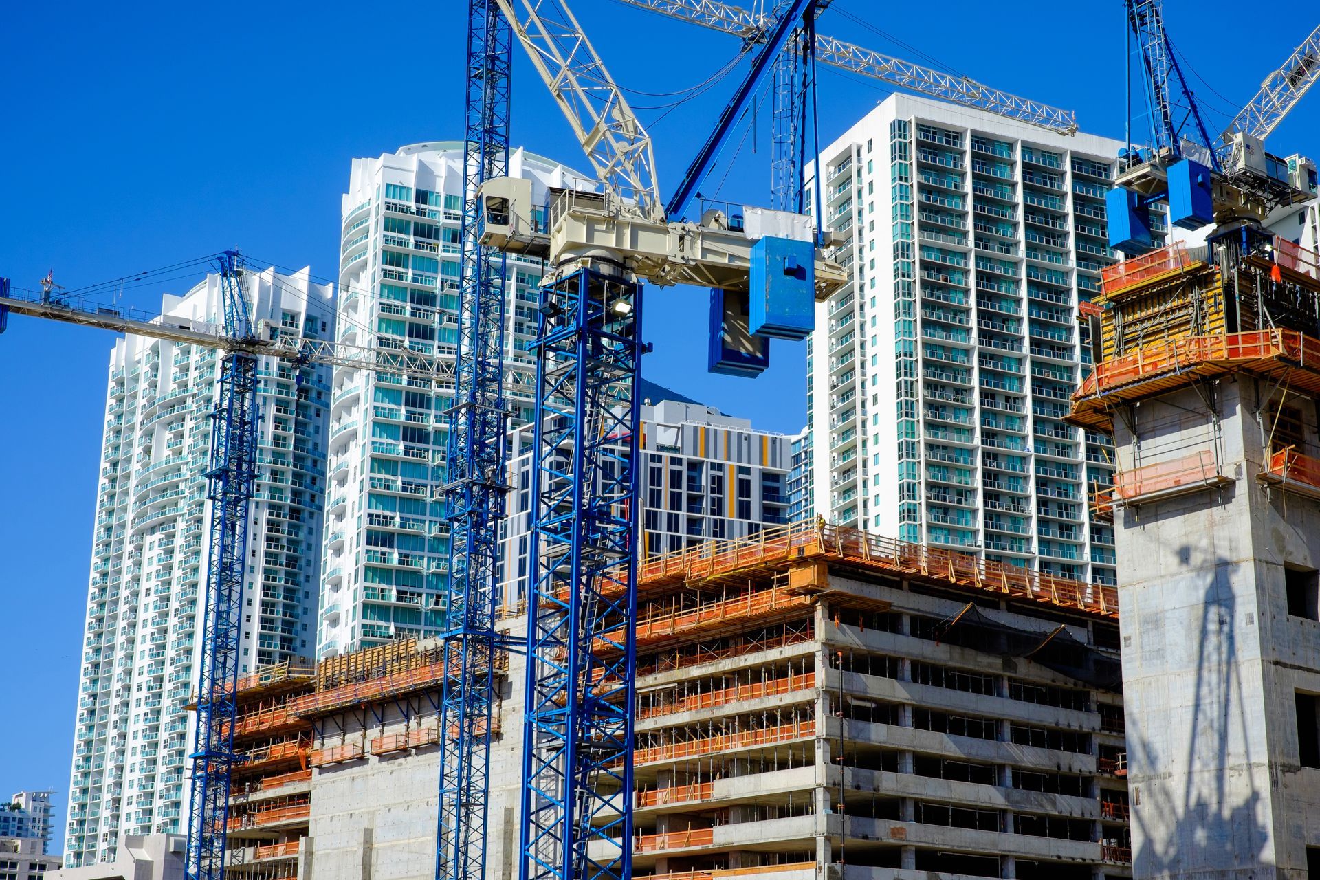 A construction site with a lot of cranes and buildings under construction.