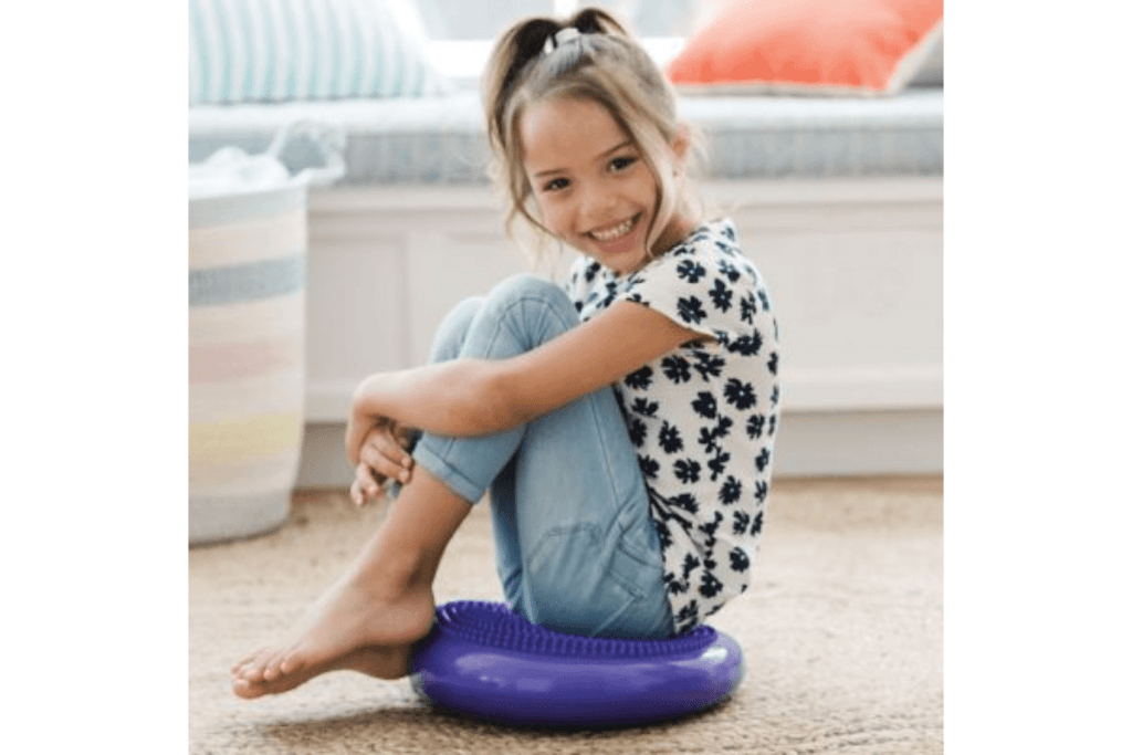 little girl smiling sitting on a toy