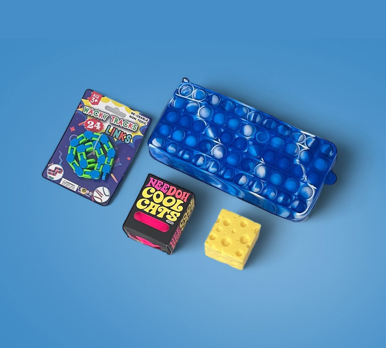 A box of cool cats fidget and a sensory box of cheese cubes on a blue surface.