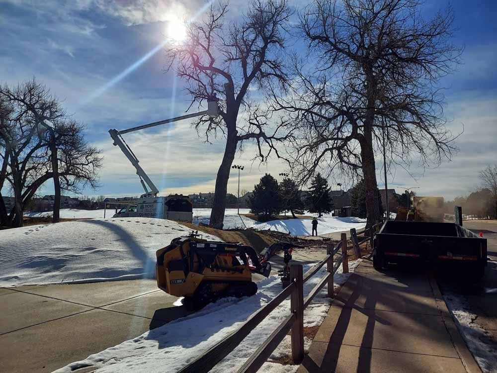 A yellow truck is parked on the side of the road in the snow.