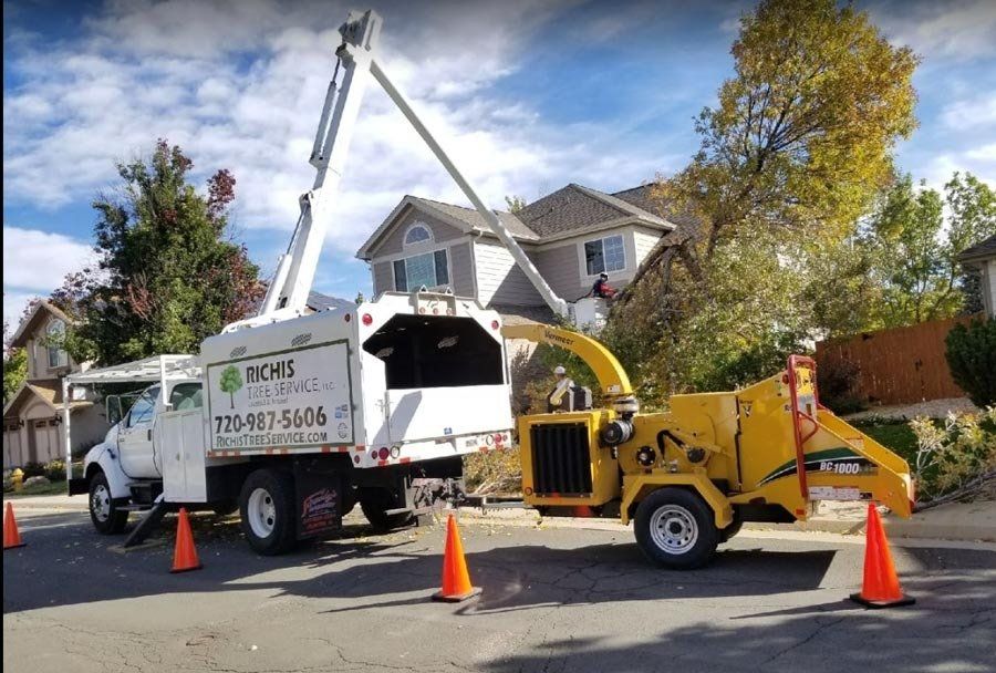 A tree chipper is parked in front of a house.