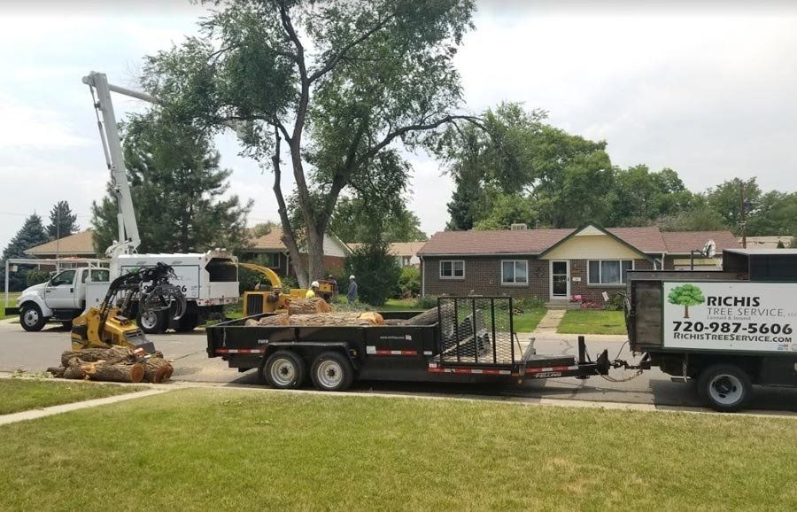 A truck with a trailer attached to it is parked in front of a house.