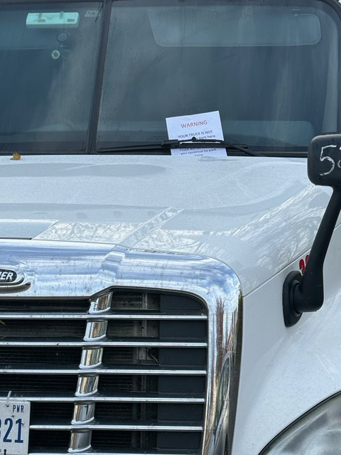 A white truck with a warning parking ticket
