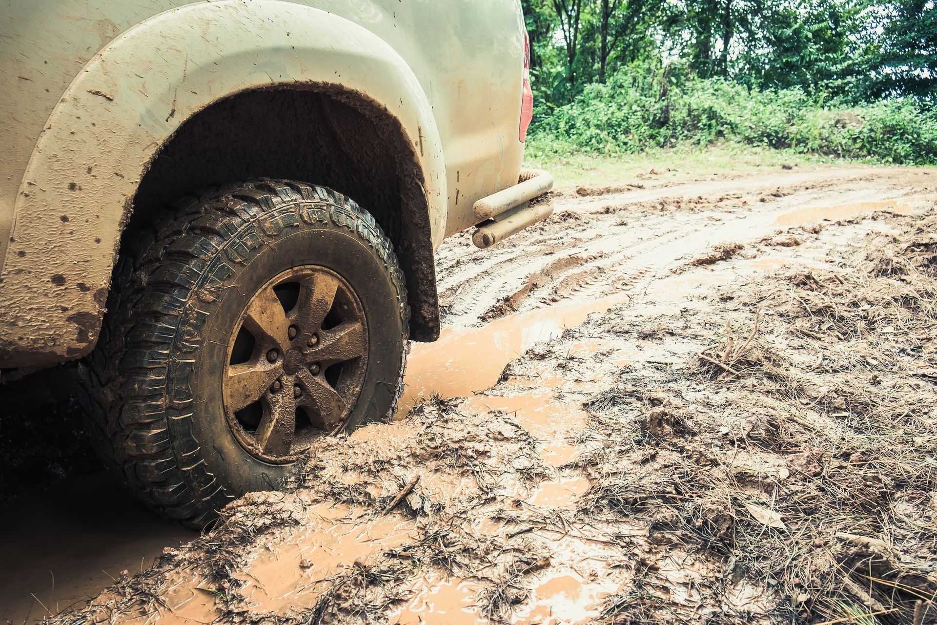 A truck is stuck in the mud on a muddy road.