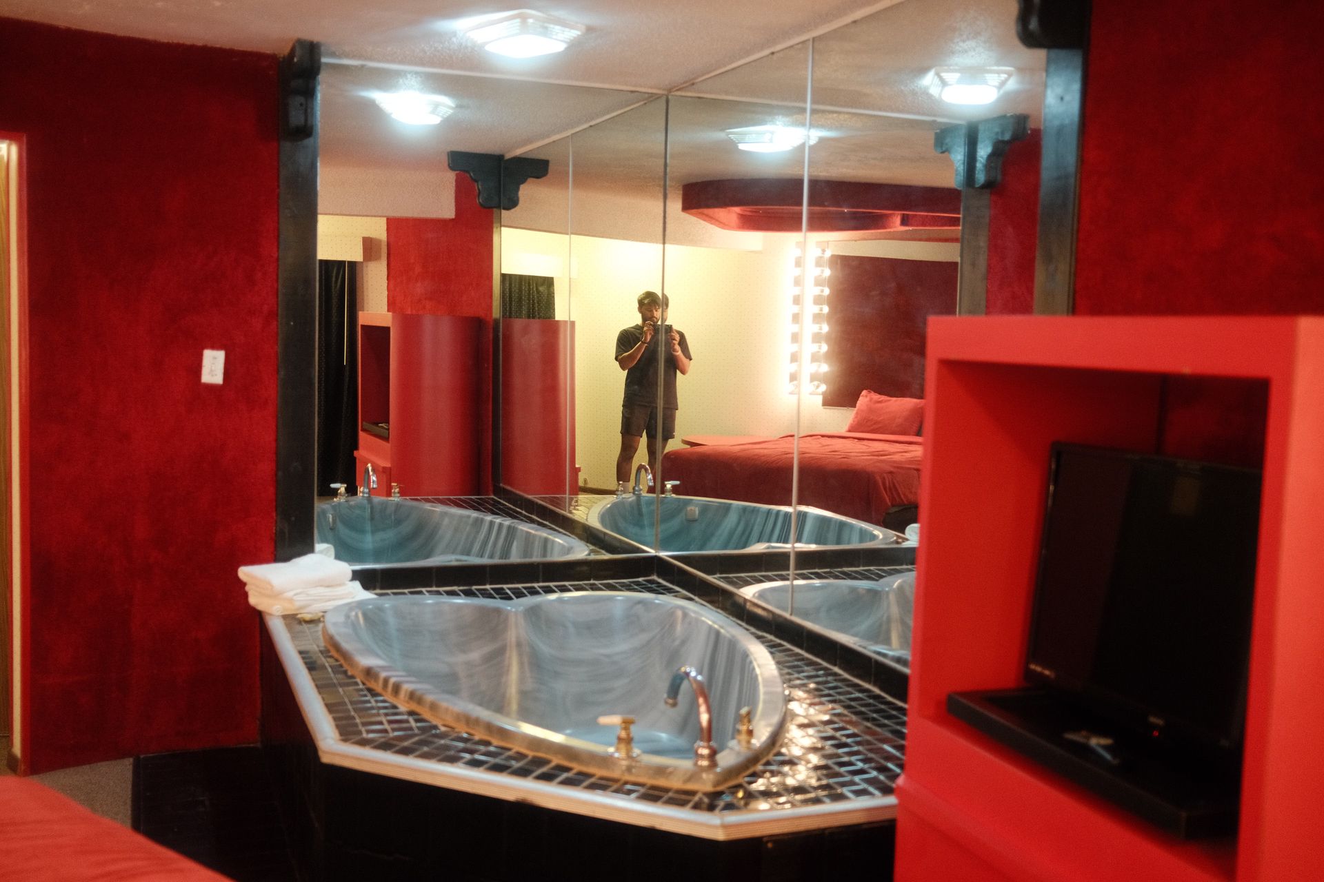 A man is taking a picture of himself in a hotel room