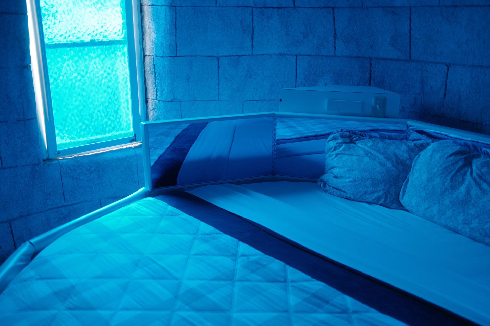 A blue room with a bed and a window