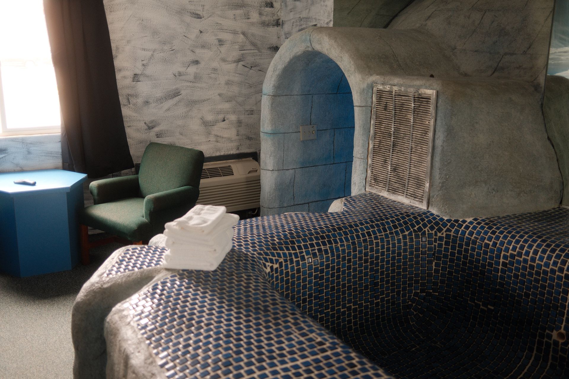 A bedroom with two beds a chair and a window