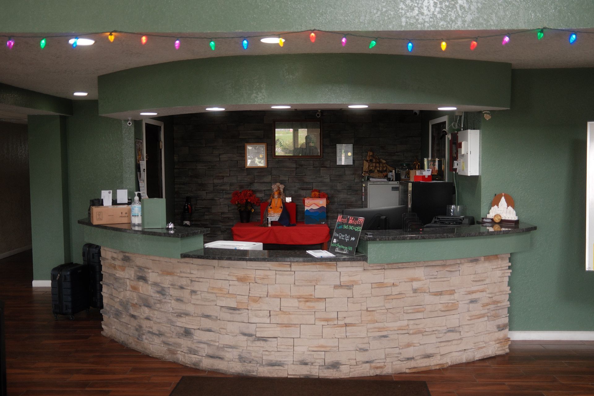 A large brick counter in a room with christmas lights on the ceiling.