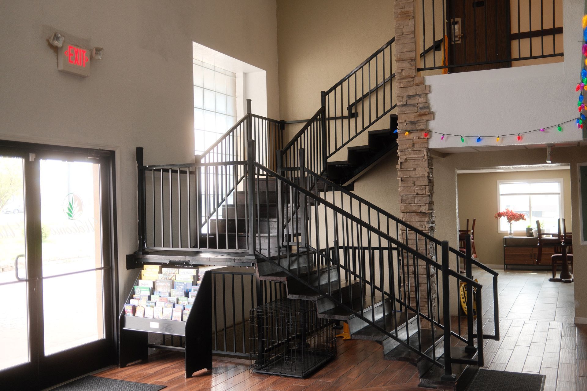 A staircase in a building with a red exit sign above it