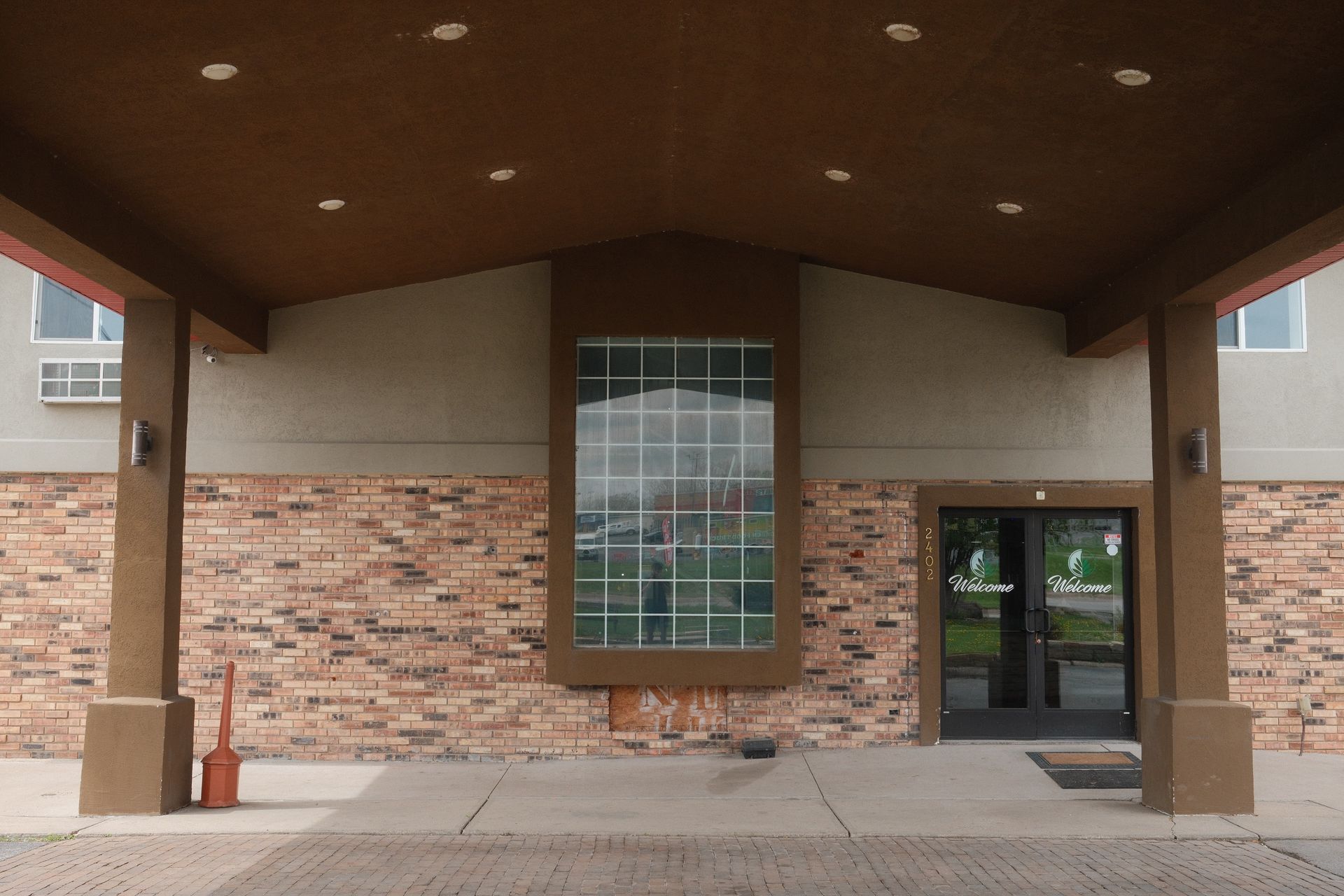 A brick building with a covered entrance and a large window