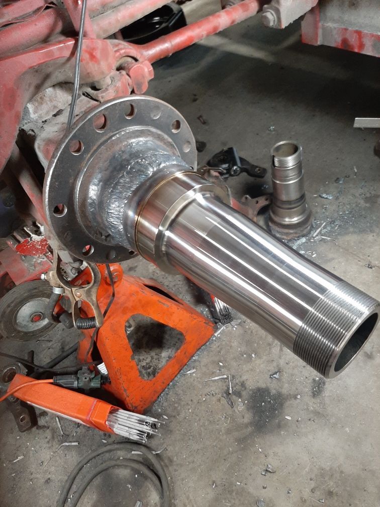 A piece of metal is sitting on top of an orange jack.