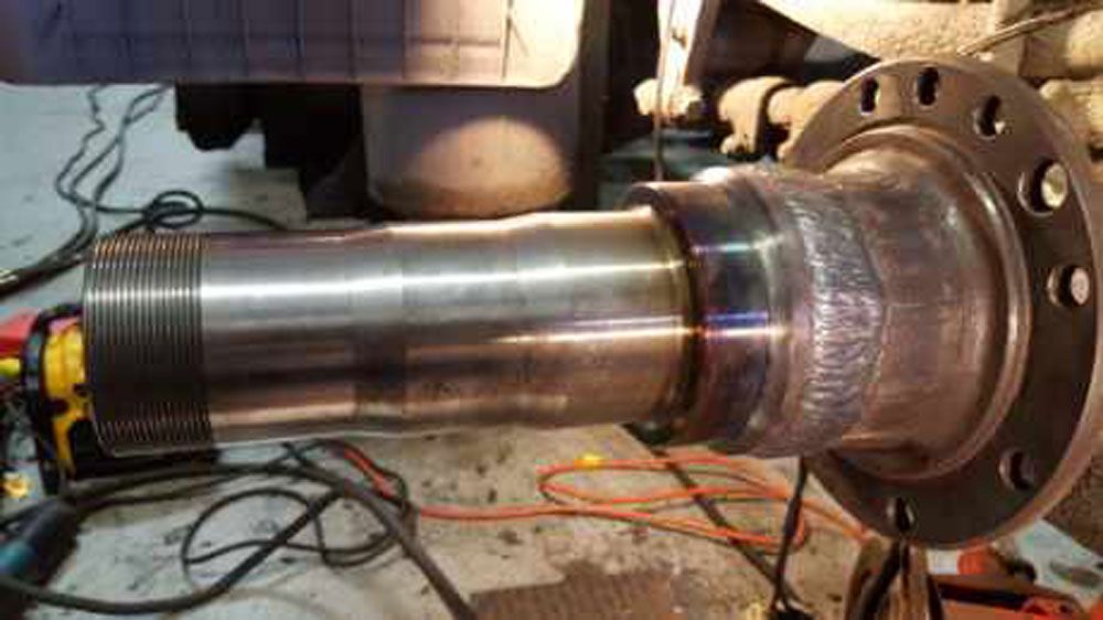 A large metal object is being worked on in a garage.