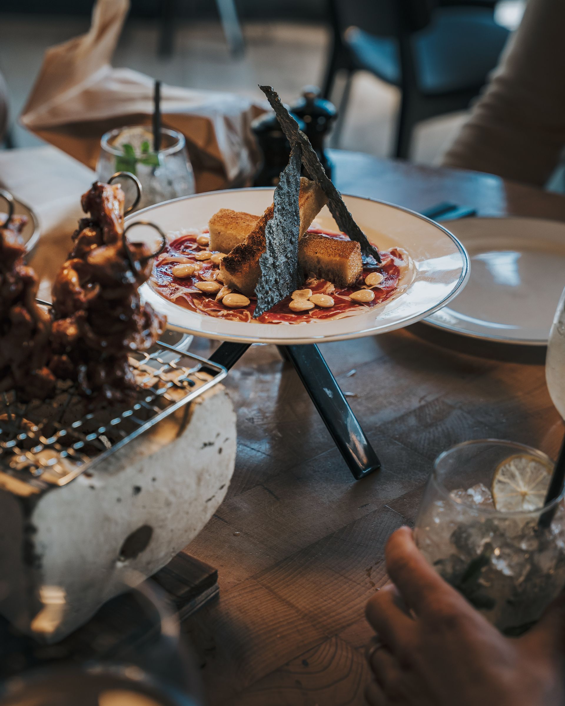 Une personne est assise à une table avec une assiette de nourriture dessus.