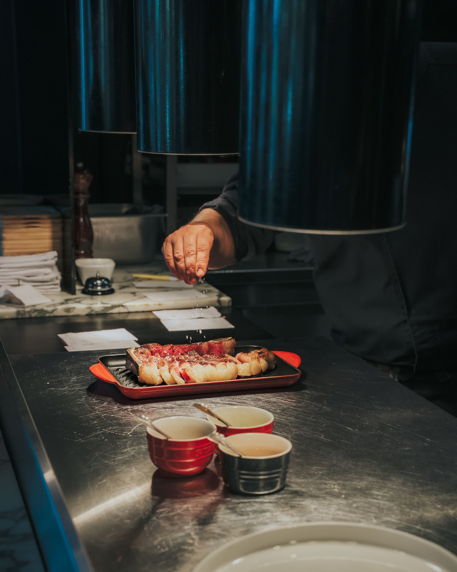 Une personne prépare de la nourriture sur un comptoir dans la cuisine du Jacobs Restaurant
