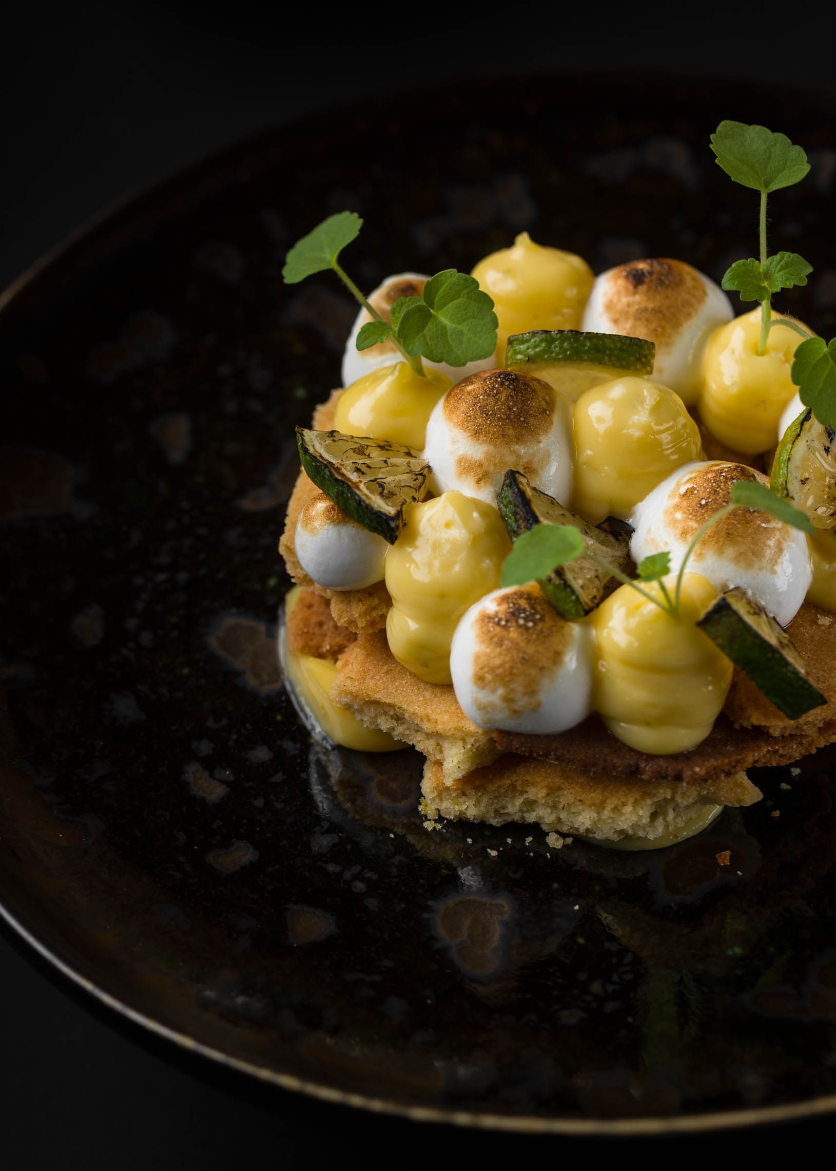 Un gros plan d'un dessert sur une assiette noire sur une table.