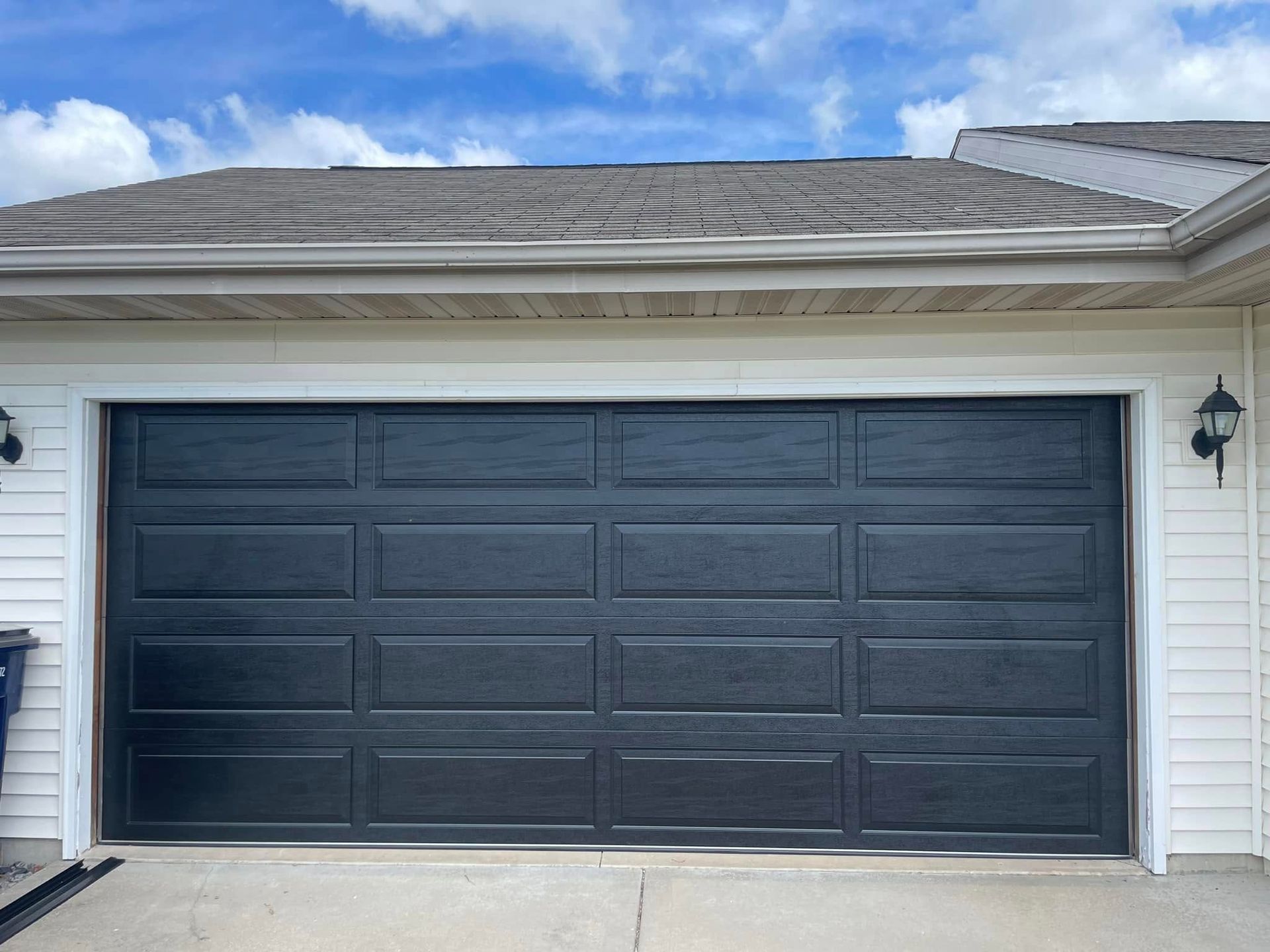 Dark gray double garage door on a white house exterior