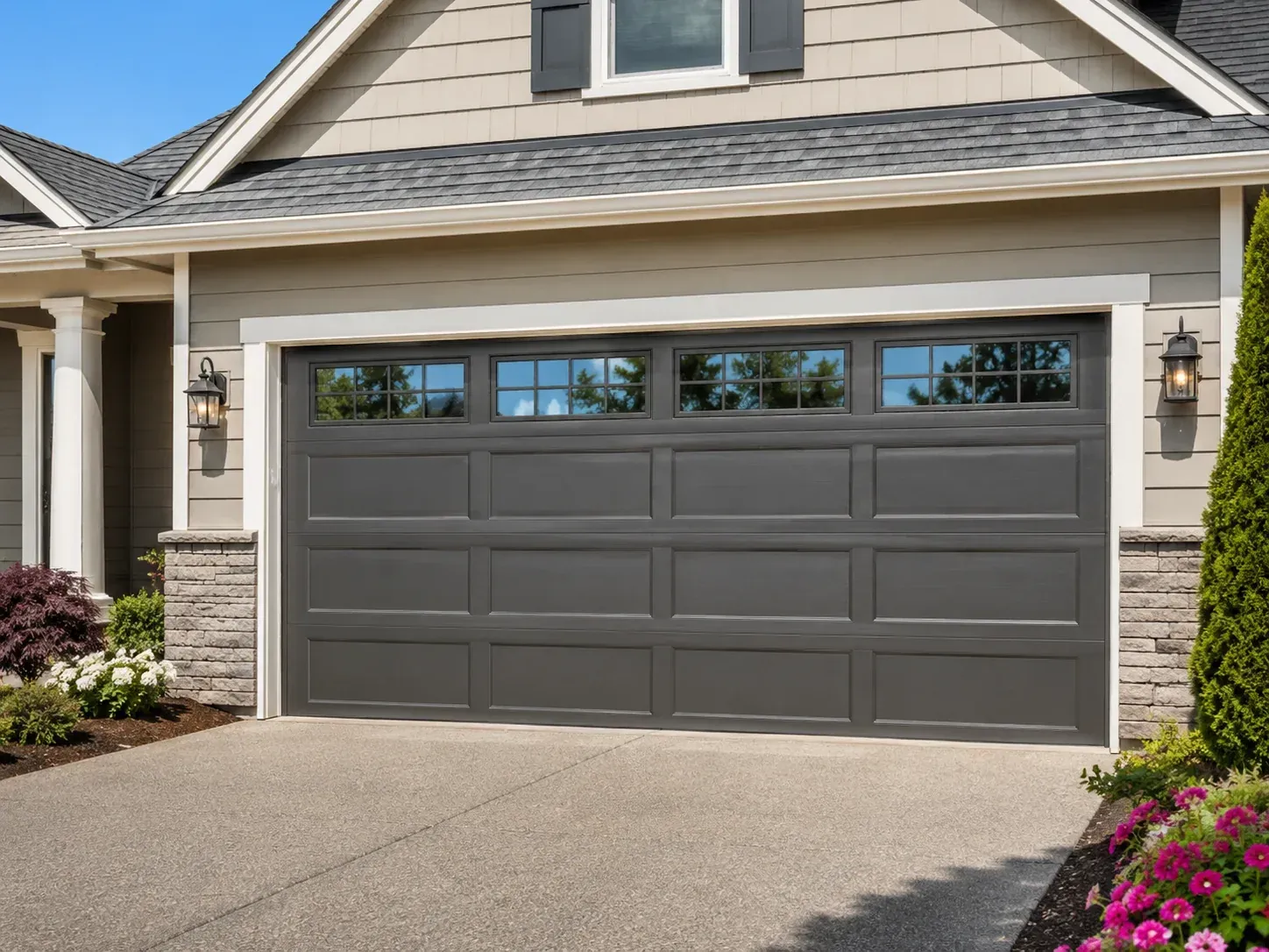 Insulated garage door with decorative top windows on a clean home exterior