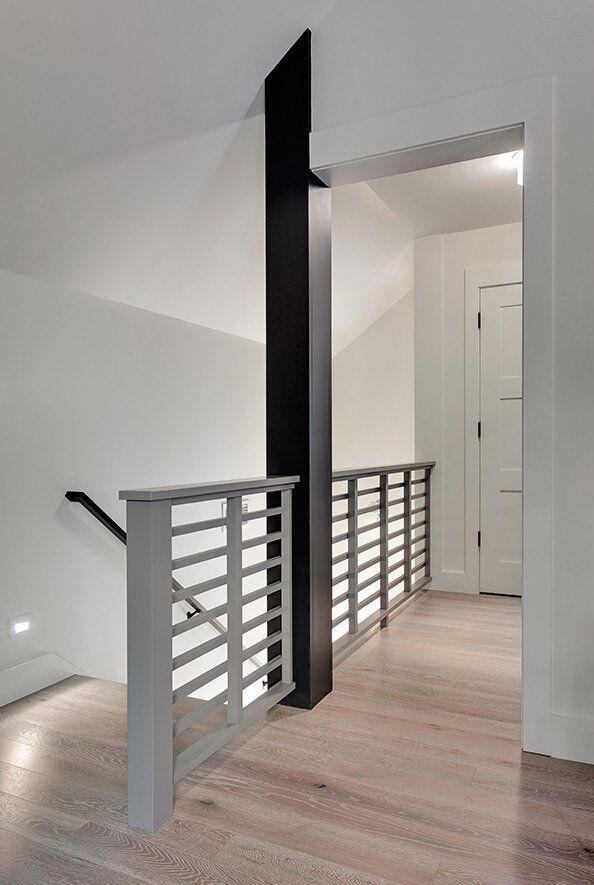 Beautiful staircase custom made hartland ct with grey railings and black beam extending to ceiling