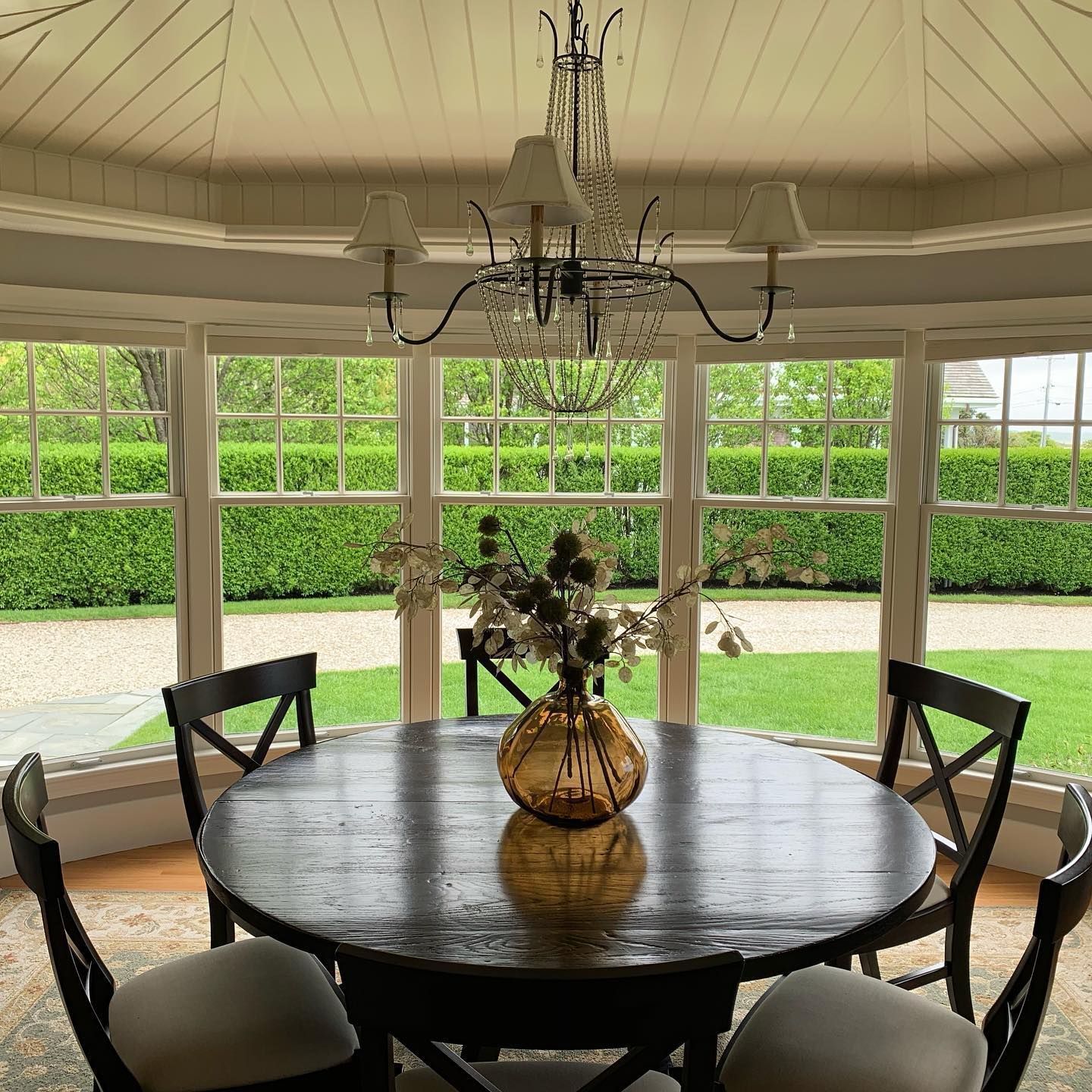 A dining room table with a vase of flowers on it
