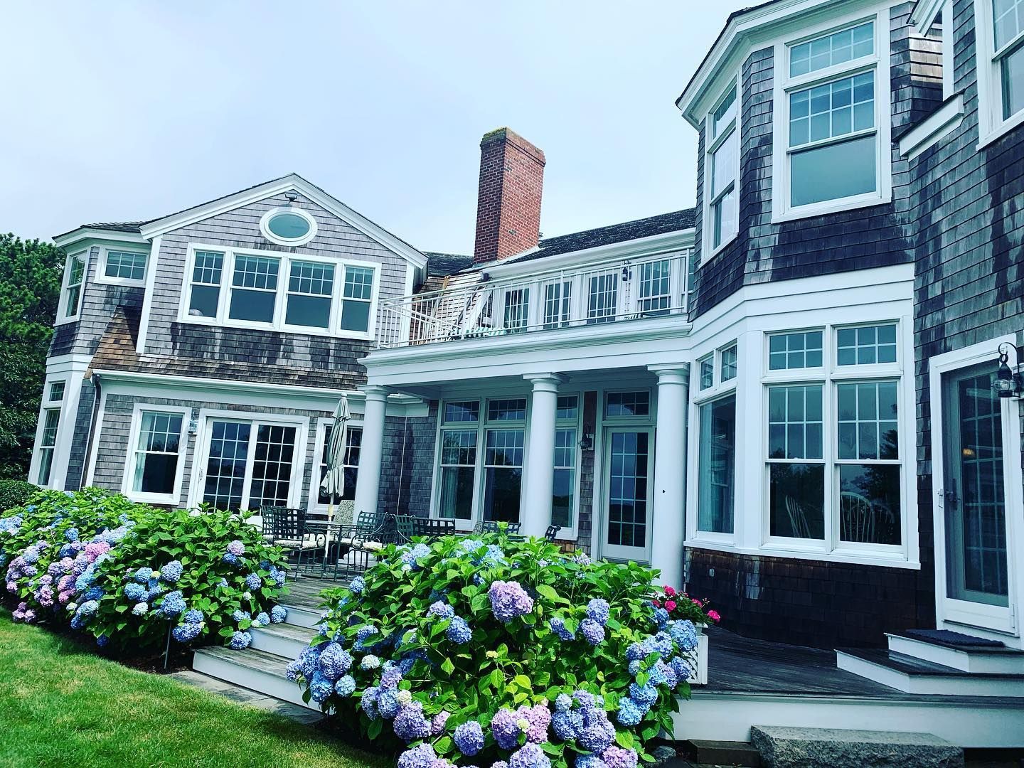 A large house with a lot of windows and flowers in front of it.