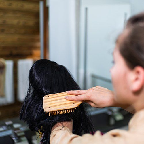 Woman Brushing Black Wig — Akron, OH — Wigs By Design