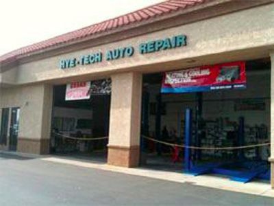 Rye-Tech Auto Repair shop exterior with sign and open garage doors. Beige building with red trim.