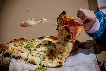 Pizza with hand — italian food in Chittenango, NY