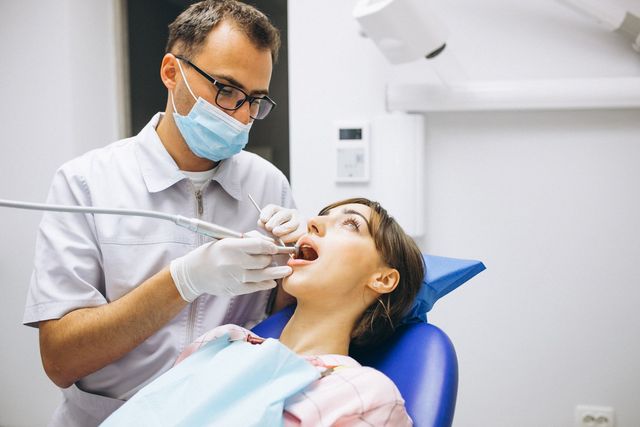 Infirmière Dentiste En Combinaison Mettant Un Bavoir Dentaire Au Patient  Avant L'examen Stomatologique Pendant La