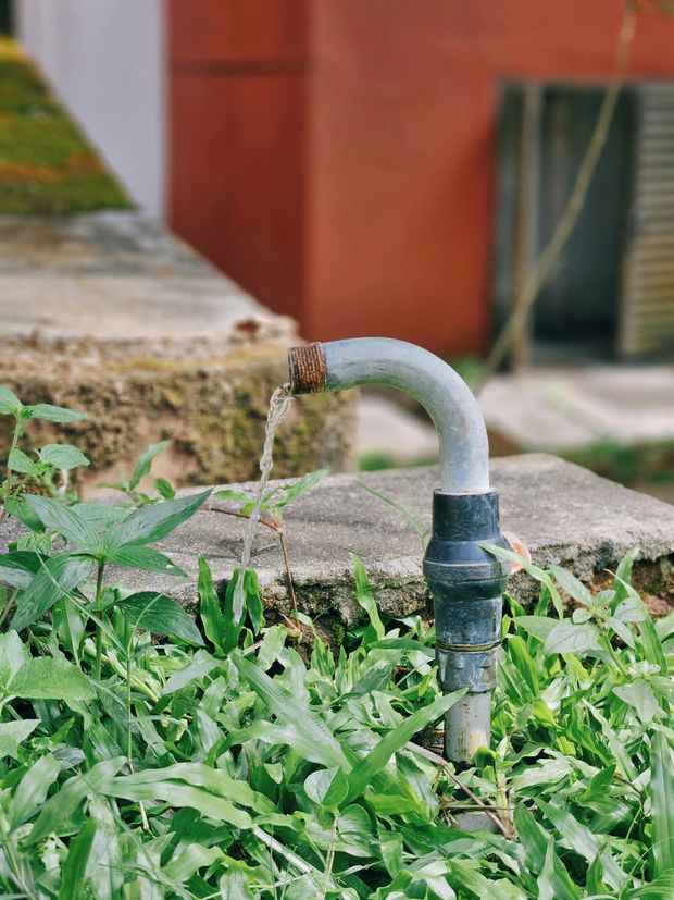 outdoor metal water pipe leaking water