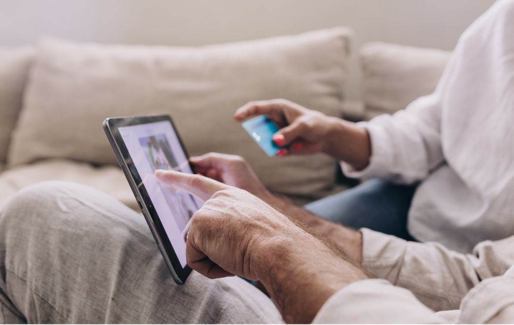 Contenedores de carga apilados en un puerto con un camión, un barco y grúas bajo un cielo nublado.